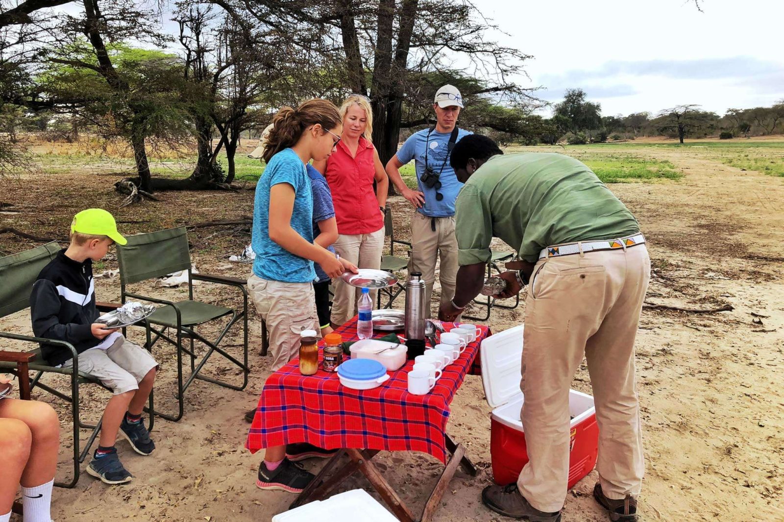 A family preparing a an evening bush snack on safari in Africa - Consider an all-inclusive private family safari holiday